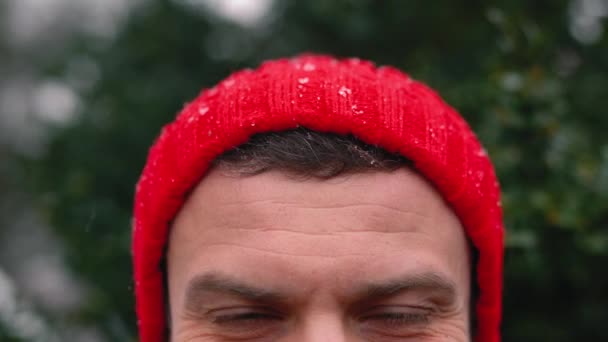 Portrait d'un homme coiffé d'une casquette rouge par temps neigeux à l'extérieur — Video