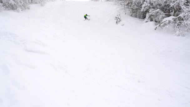 Екстремальний сноубордист катається на свіжому порошку снігу вниз по крутому гірському схилу — стокове відео