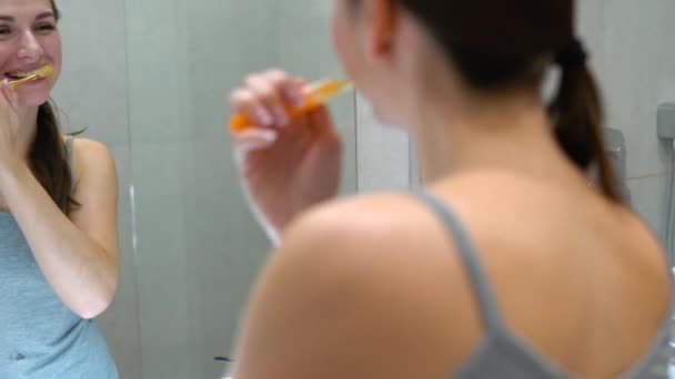 Güzel bir kadın sabah tuvalette dişlerini fırçalama. Sabah hijyen. — Stok video