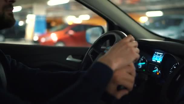 Man driver igenom en parkeringsplats och letar efter en plats att parkera — Stockvideo