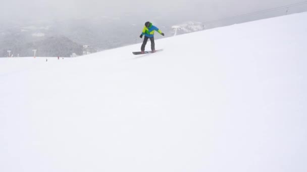 Ακραία snowboarder ιππασία φρέσκο χιόνι κάτω από την απότομη πλαγιά — Αρχείο Βίντεο