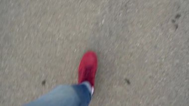 Kırmızı spor ayakkabıları asfaltta yürürken bacaklarda mens üstten görünüm