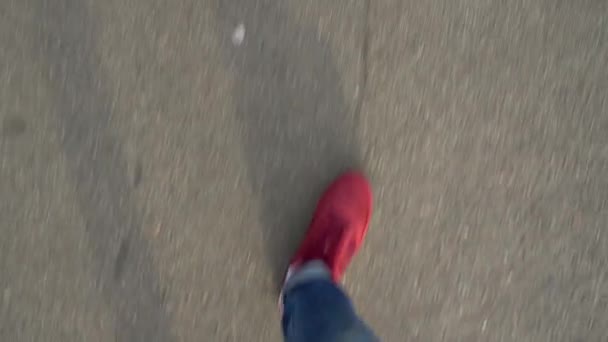 Ovanifrån av mens ben i röda sneakers promenader på asfalt — Stockvideo