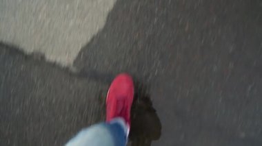 Islak asfalt üzerine yürüyen kırmızı spor ayakkabıları mens bacaklarda Üstten Görünüm