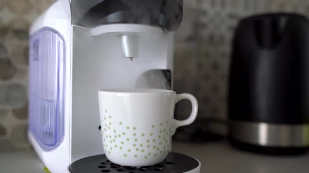 ホームのカプセル コーヒー マシンは、新鮮なコーヒーのカップを準備します。料理の終わりに蒸気の雲 — ストック動画