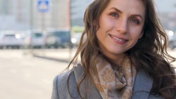 Portret van een vrouw met een kapsel en neutrale make-up op een stad achtergrond closeup — Stockvideo