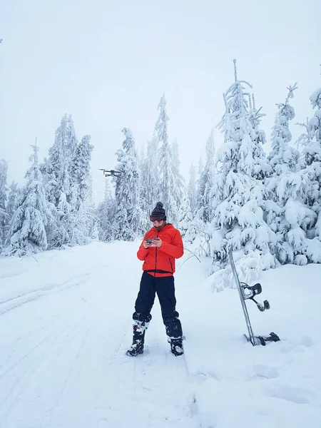 Snowboarder ελέγχει το drone σ ' ένα διάλειμμα στο πατινάζ — Φωτογραφία Αρχείου