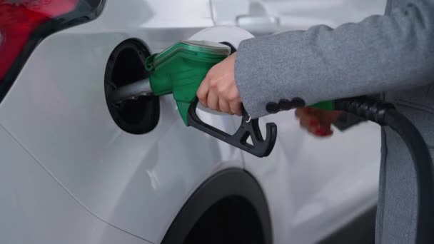 Mulher enche gasolina em seu carro em um posto de gasolina perto — Vídeo de Stock