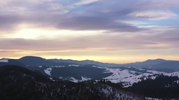 Vista aérea de nuvens céu azul sobre incrível paisagem de montanhas nevadas e floresta conífera nas encostas — Vídeo de Stock