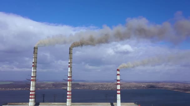 Вид с воздуха на старую теплоэлектростанцию с большими трубами в сельской местности рядом с водохранилищем — стоковое видео