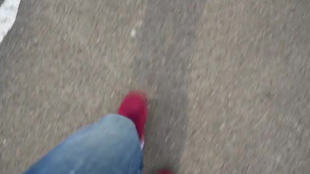 Vista superior de piernas de hombre en zapatillas rojas caminando sobre asfalto — Vídeos de Stock