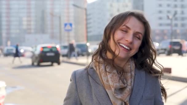 Retrato de una mujer con un peinado y maquillaje neutro en un primer plano de fondo de ciudad — Vídeo de stock