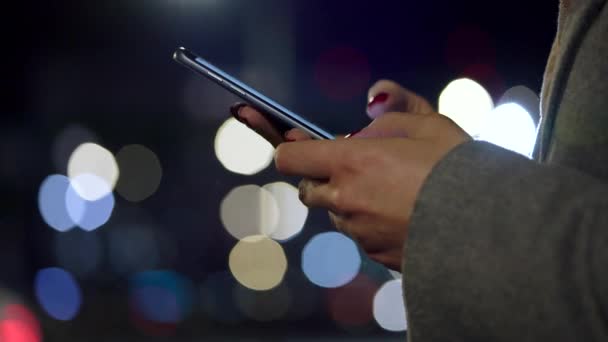 Női kezek használ smartphone homályos city lights háttér — Stock videók