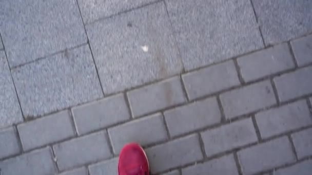 Vue du dessus des jambes masculines en baskets, qui longent le trottoir, rencontrent les jambes féminines en bottes, puis marchent ensemble — Video