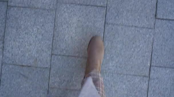 Bovenaanzicht van vrouwelijke benen in laarzen wandelen op de stoep — Stockvideo