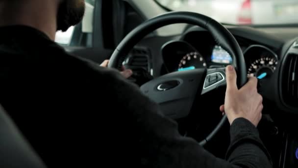 L'uomo sta guidando auto attraverso un parcheggio ed è alla ricerca di un posto per parcheggiare o guidare via — Video Stock