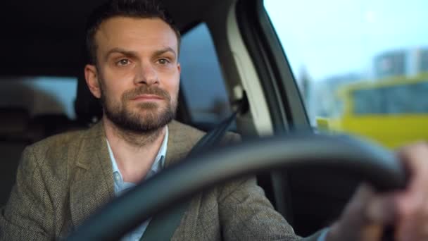 Satisfait homme barbu conduisant une voiture dans la rue par temps ensoleillé — Video