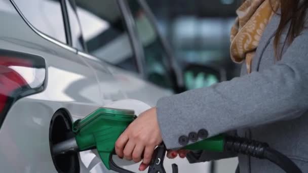 Vrouw vult benzine in haar auto bij een benzinestation closeup — Stockvideo