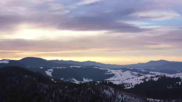 Utsikt från höjden på moln blå himmel över fantastiska landskap med snötäckta berg och barrskog på sluttningarna — Stockvideo