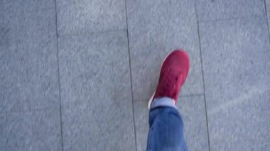 Kırmızı spor ayakkabılar kaldırım boyunca yürürken bacaklarda mens Üstten Görünüm