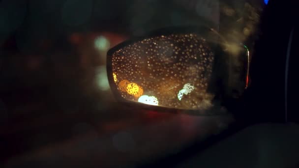 Stadt Lichter auf Auto Rückspiegel in der Nacht bei Regen gesehen — Stockvideo