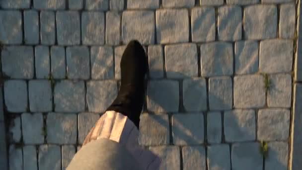 Ovanifrån av kvinnliga ben i mockastövlar och veckad kjol walking på trottoaren — Stockvideo