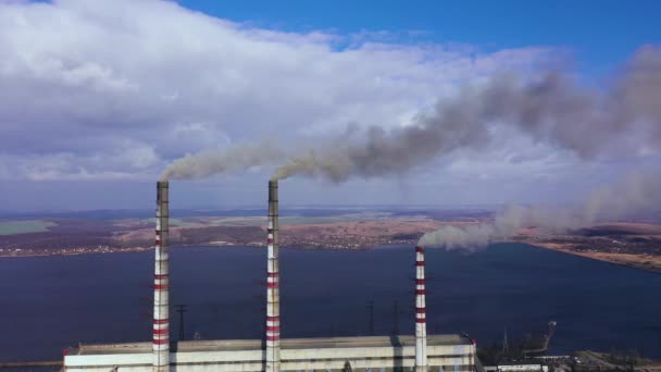 Вид с воздуха на старую теплоэлектростанцию с большими трубами в сельской местности рядом с водохранилищем — стоковое видео