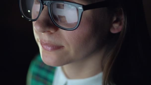 Donna in occhiali guardando sul monitor e navigare in Internet. Lo schermo del monitor si riflette negli occhiali — Video Stock