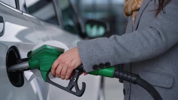 Vrouw vult benzine in haar auto bij een benzinestation closeup — Stockvideo