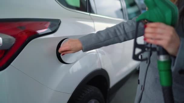 Vrouw vult benzine in haar auto bij een benzinestation closeup — Stockvideo