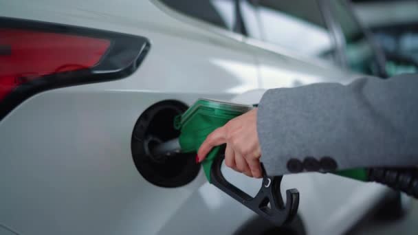 Vrouw vult benzine in haar auto bij een benzinestation closeup — Stockvideo