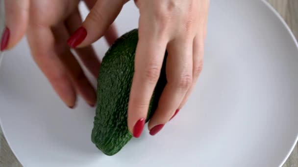 Женщина открывает авокадо. Концепция современного здорового питания — стоковое видео