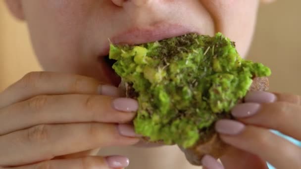 Vrouw eten veganistische avocado sandwich close-up — Stockvideo