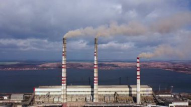 Havzanın yakınındaki kırsal manzara içinde büyük bacalar ile eski termoelektrik bitkinin havadan görünümü