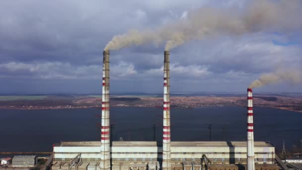 Vista aérea da antiga usina termoelétrica com grandes chaminés em uma paisagem rural perto do reservatório — Vídeo de Stock