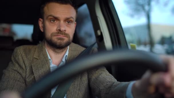 Soddisfatto uomo barbuto alla guida di una macchina in fondo alla strada con tempo soleggiato — Video Stock