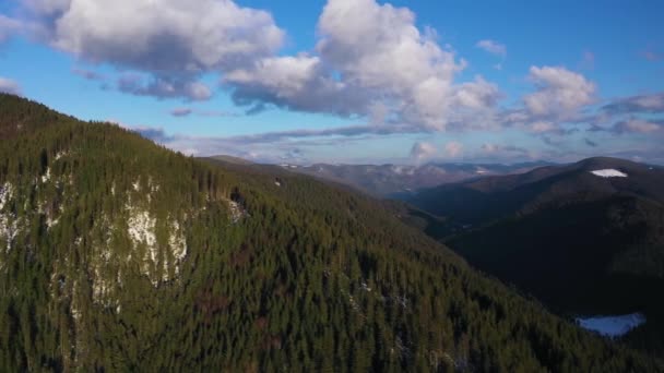 높은 눈 덮인 산과 슬로프에 잠수 림의 놀라운 풍경을 통해 푸른 하늘에 구름에 공기에서 보기. 다른 속도로 촬영 - 가속 및 정상 — 비디오