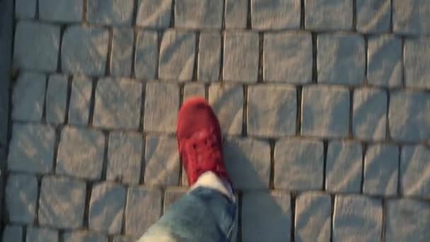 Vista dall'alto di gambe da uomo in scarpe da ginnastica rosse che camminano lungo il marciapiede — Video Stock