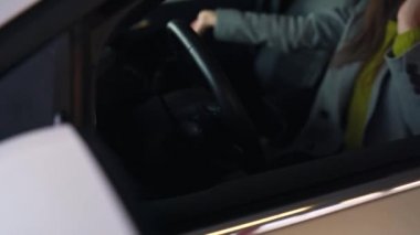 Kadın kızgın ve üzgün, çünkü arabası bozuldu. Telefonla yardım almaya çalışıyor..