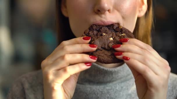 Una donna mangia un biscotto al cioccolato in un caffè — Video Stock