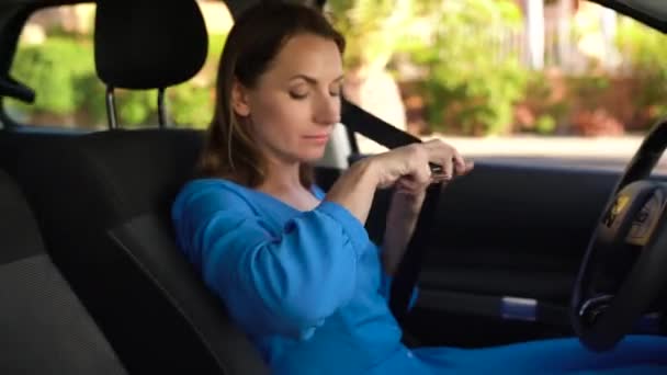 女人坐在车辆在开车前紧固汽车安全座椅安全带 — 图库视频影像