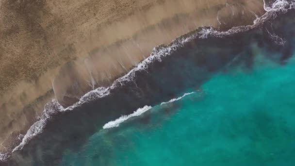 大西洋上の砂漠のビーチのトップビュー。テネリフェ島の海岸。海岸に到達する海の波の空中ドローン映像 — ストック動画