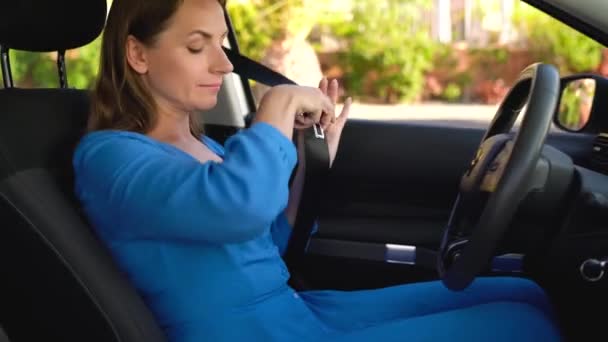 Женщина пристегивает ремень безопасности автомобиля, сидя внутри автомобиля перед вождением — стоковое видео