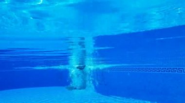 Bir adam suyun altında yüzerken sualtı çekim