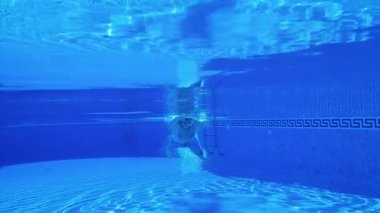 Bir adam suyun altında yüzerken sualtı çekim