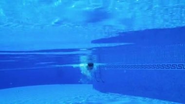 Bir adam suyun altında yüzerken sualtı çekim