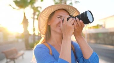 Fotoğrafçı turist kadın gün batımında güzel bir tropikal manzara kamera ile fotoğraf çekmek