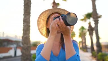 Fotoğrafçı turist kadın gün batımında güzel bir tropikal manzara kamera ile fotoğraf çekmek