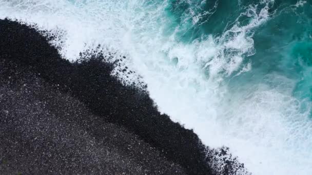 Bovenaanzicht van een verlaten zwarte vulkanische strand. Kust van het eiland Tenerife. Luchtfoto drone beelden van golven van de zee oever bereiken — Stockvideo