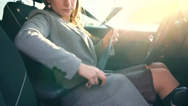 Woman fastening car safety seat belt while sitting inside of vehicle before driving — Stock Video